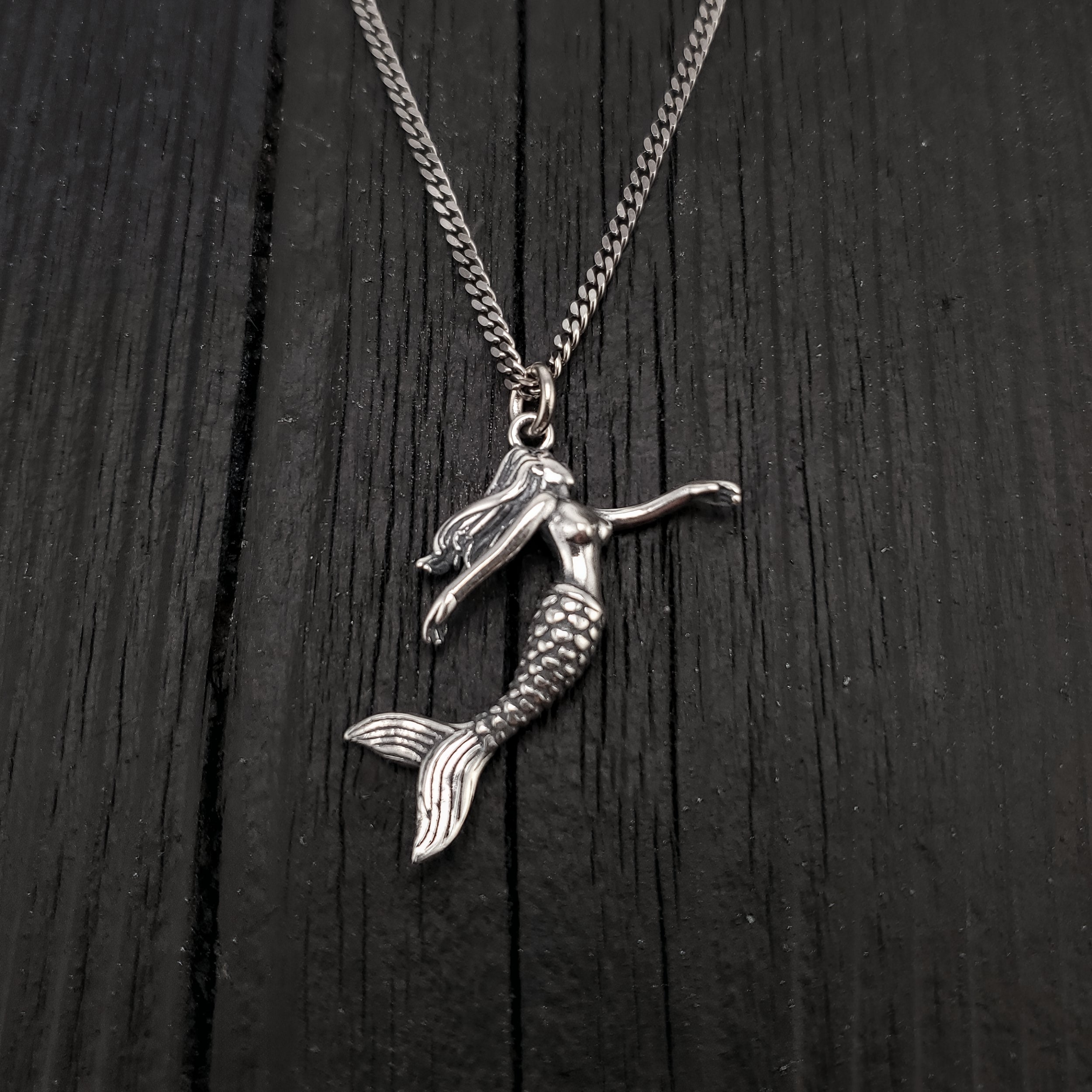 Pendant width: 1 Inches; Pendant height: 1 1/4 Inches. This three dimensional mermaid is cast of sterling silver, it is a solid sterling casting not hollow. Being expertly detailed on all sides, it can be worn with either side showing.