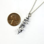 Delicate necklace with small silver coin on top
