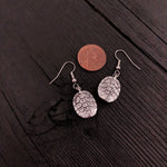 Penny atop elegant earrings, blending currency and jewelry | Moon Raven