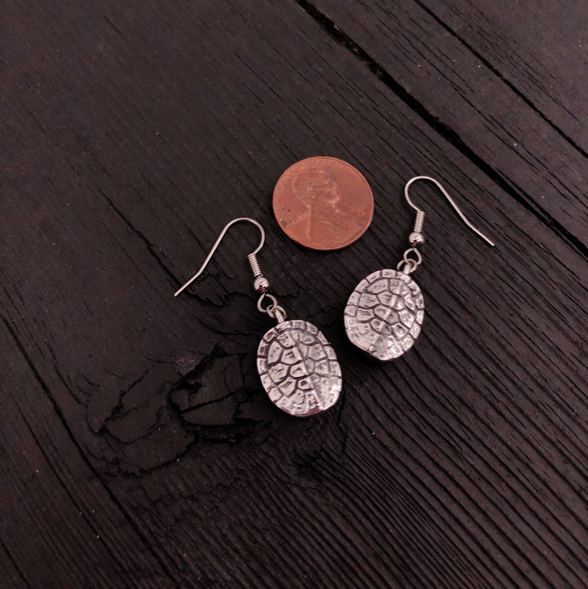Penny atop elegant earrings, blending currency and jewelry | Moon Raven