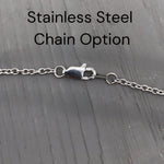 a close-up view of a stainless steel chain with a clasp, placed on a wooden surface.