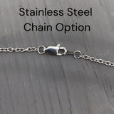 a close-up view of a stainless steel chain with a clasp, placed on a wooden surface.