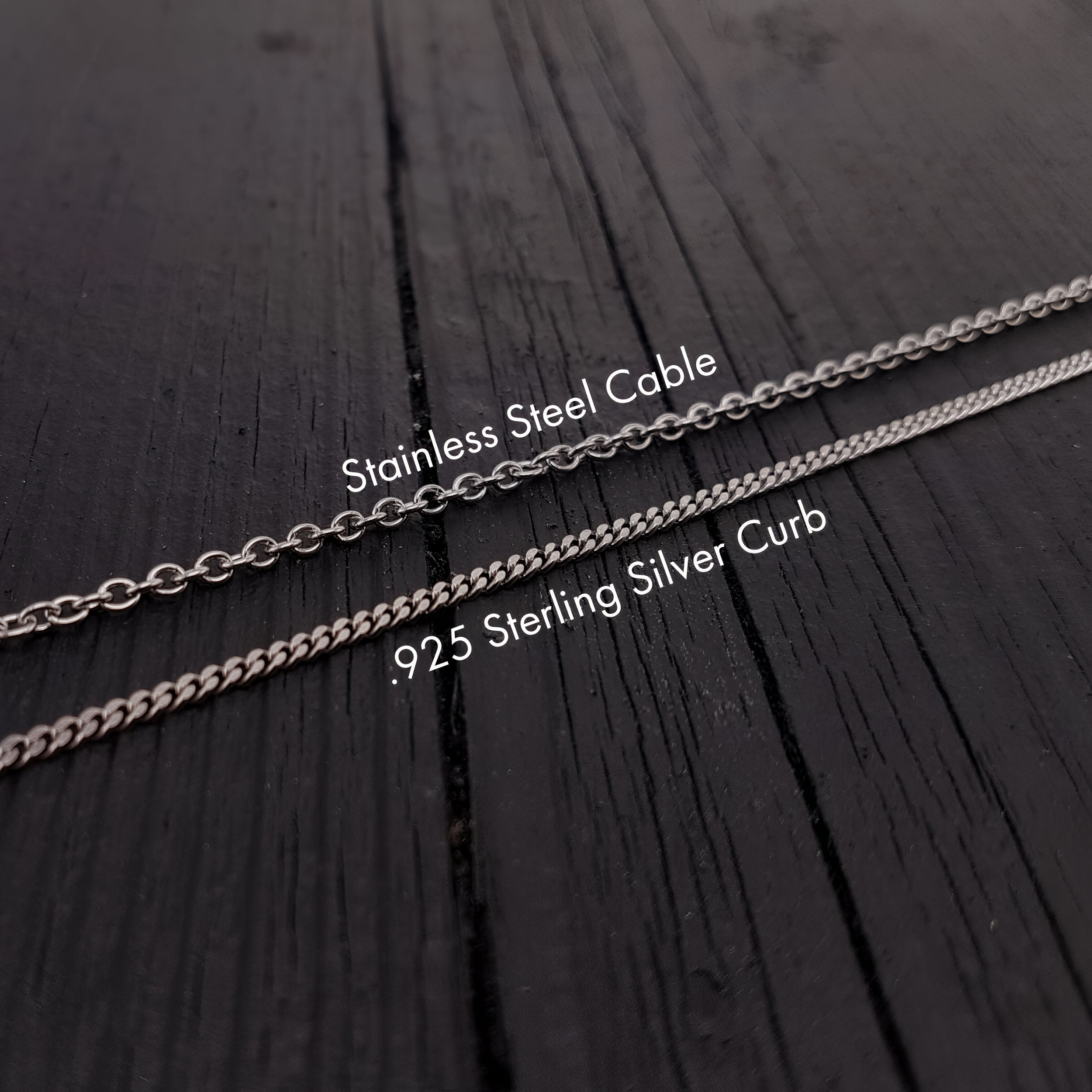 three different types of silver chains laid out on a wooden surface.