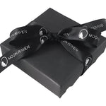A black gift box with a black ribbon tied around it, featuring the text "Moon Raven" printed on it.