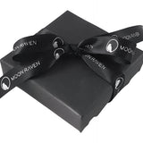 A black gift box with a black ribbon tied around it, featuring the text "Moon Raven" printed on it.